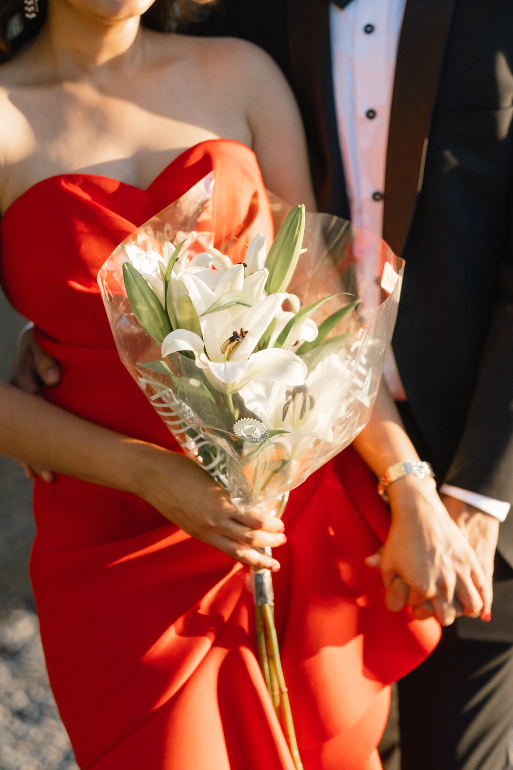 The bride and groom holdings hands while the bride grasps her bouquet