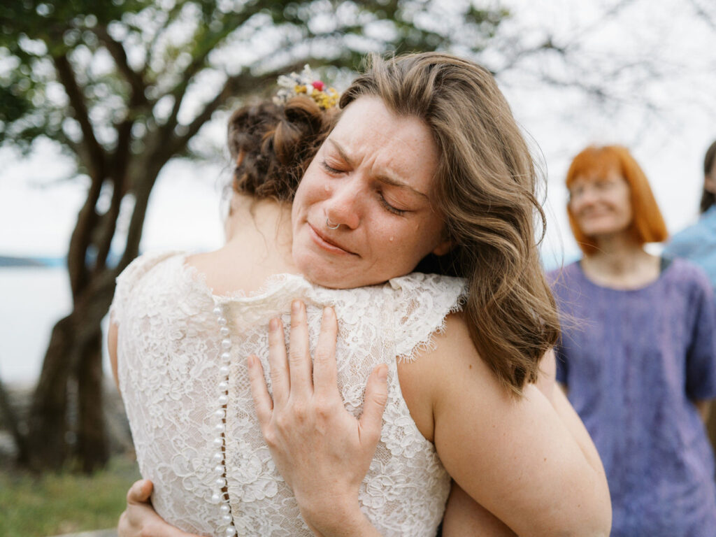 Wedding guest tearfully hugs the bride at Guemes Island Resort wedding.