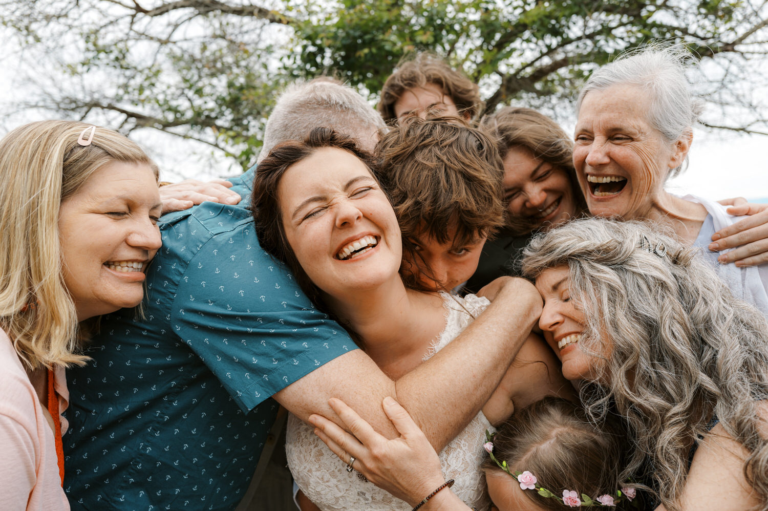 Bride surrounded by wedding guests for an impromptu hug