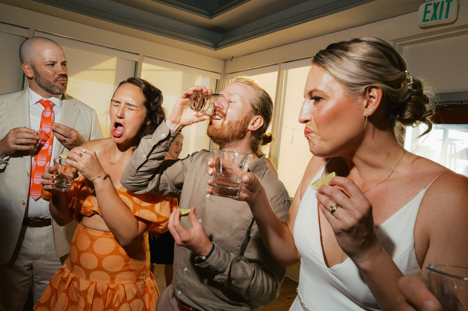 The Best Documentary Wedding Photography of 2025 5 Friends take tequila shots and laugh during an intimate wedding reception — candid documentary wedding photography in Seattle