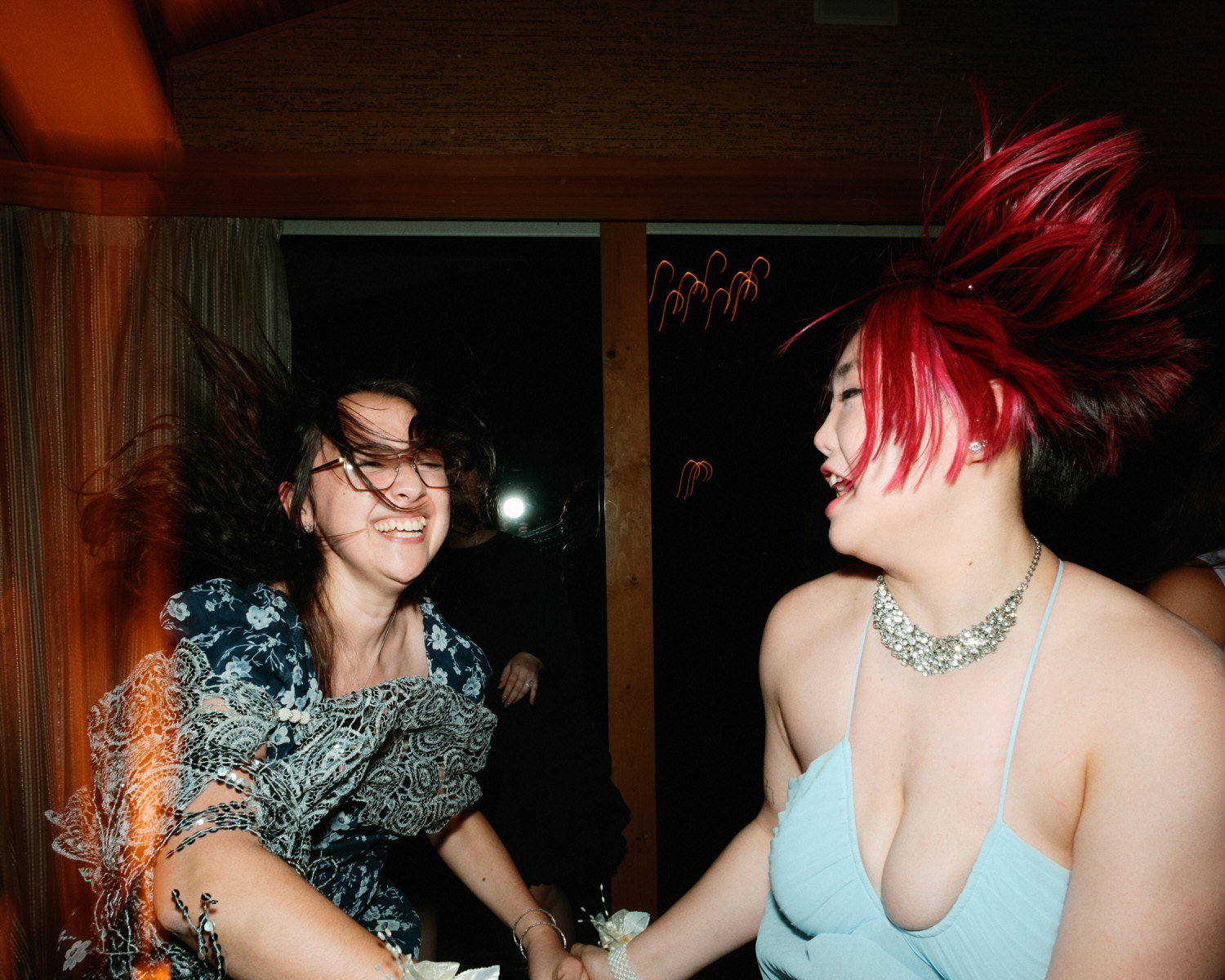 The Best Documentary Wedding Photography of 2025 13 wo friends dance with hair flying during a packed wedding reception