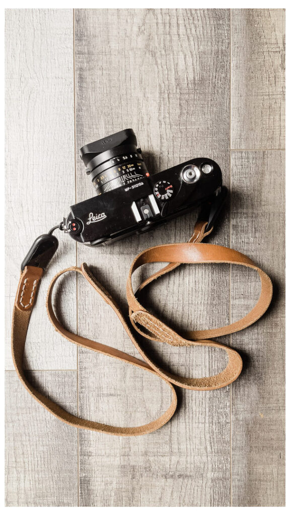 Why I Switched from Fujifilm to Leica for my Documentary Wedding Photography Business 2 A Leica MP film camera with brown leather strap.