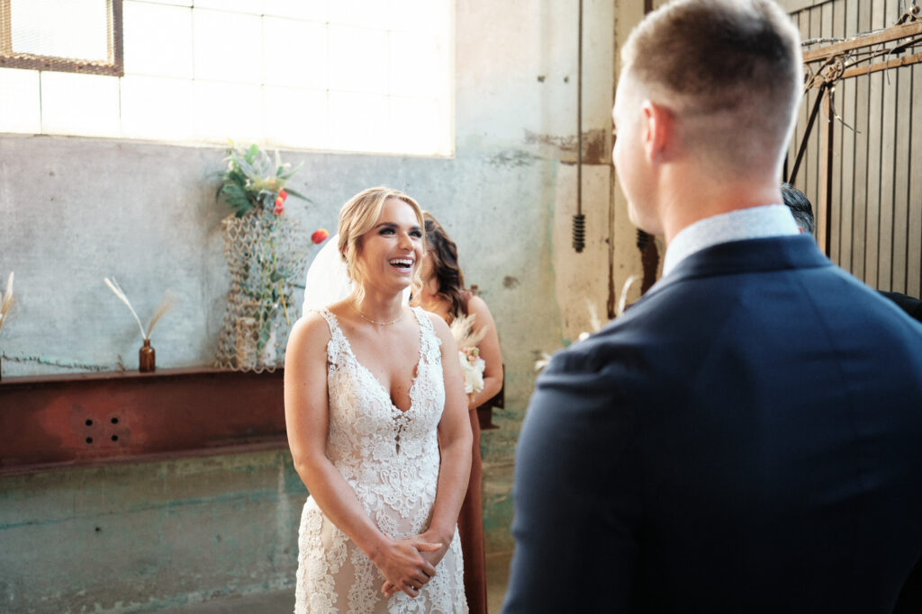 Bride Laughs as the groom reads his vows during a wedding ceremony at The Press Room Tacoma