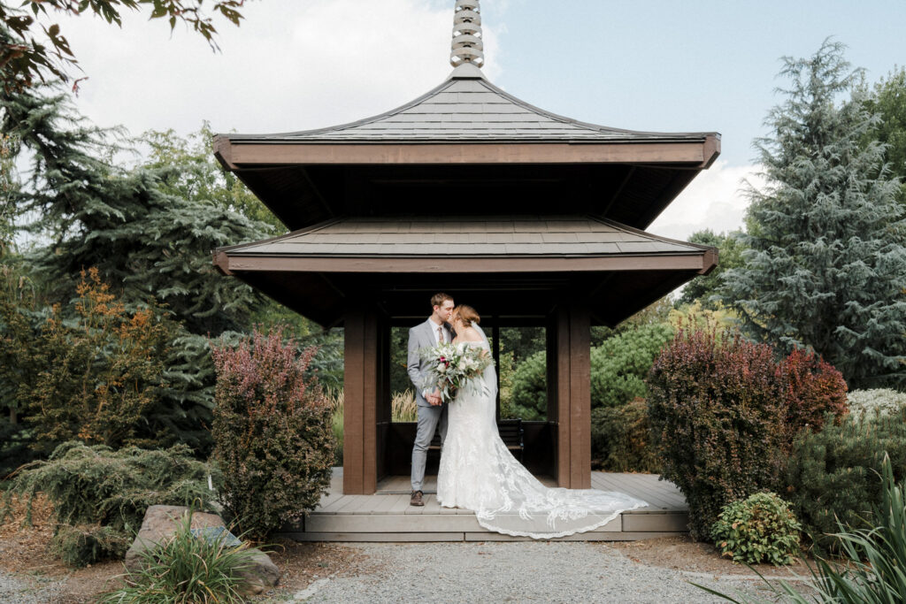 Bride kisses the groom under a Japanese pagoda