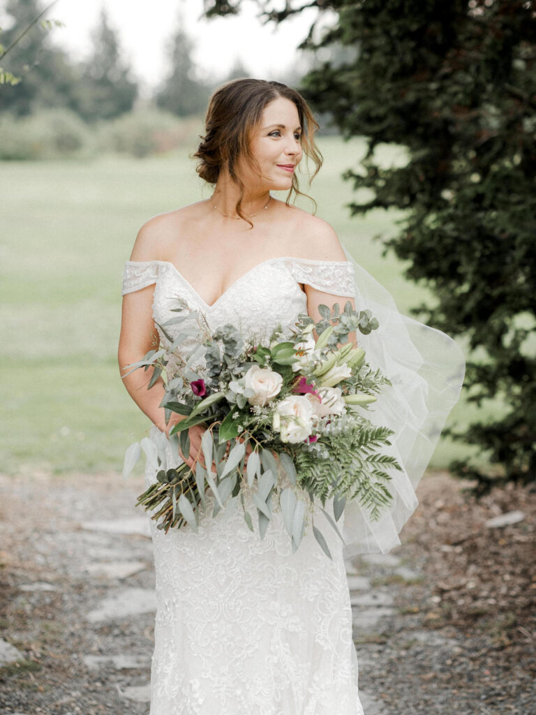 Bride looks off camera as the wind catches her veil