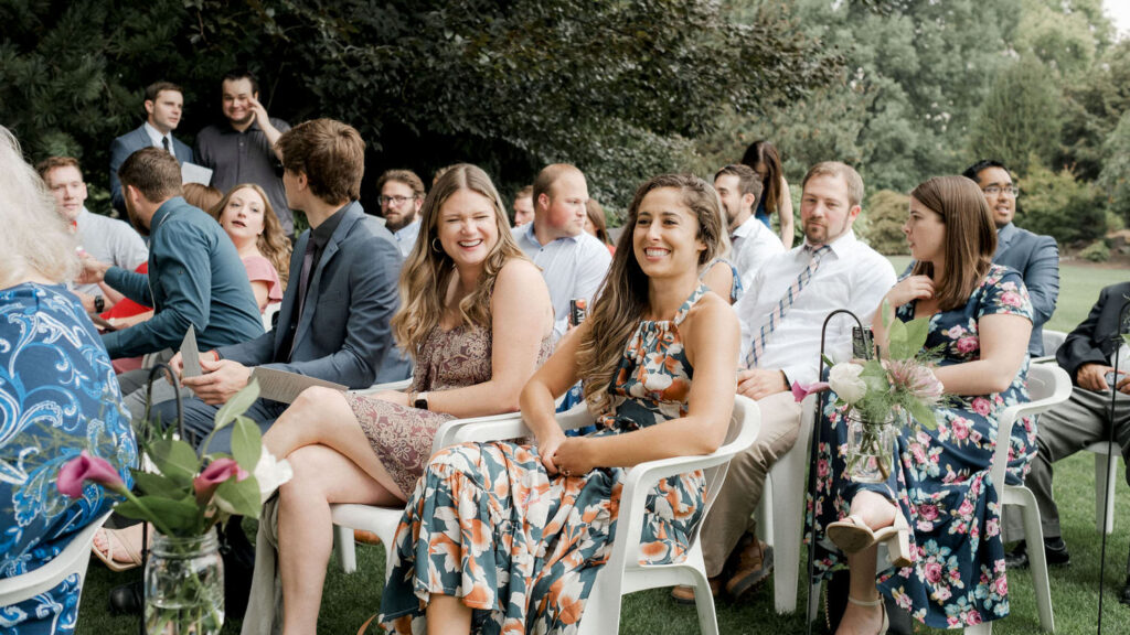 Wedding guests laugh before the ceremony starts