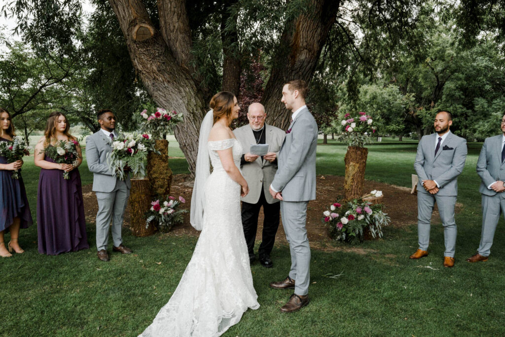 Bride and groom look at each other at the wedding officiant speaks