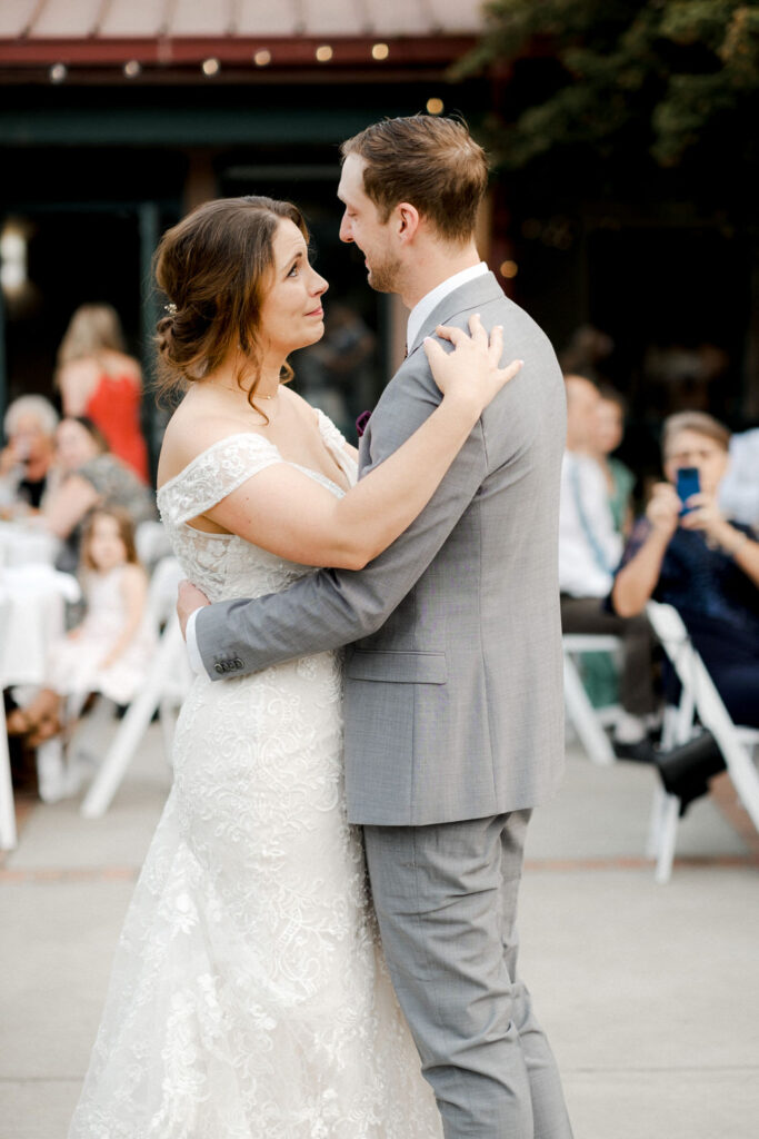 Emotional bride looks at the groom during the first dance