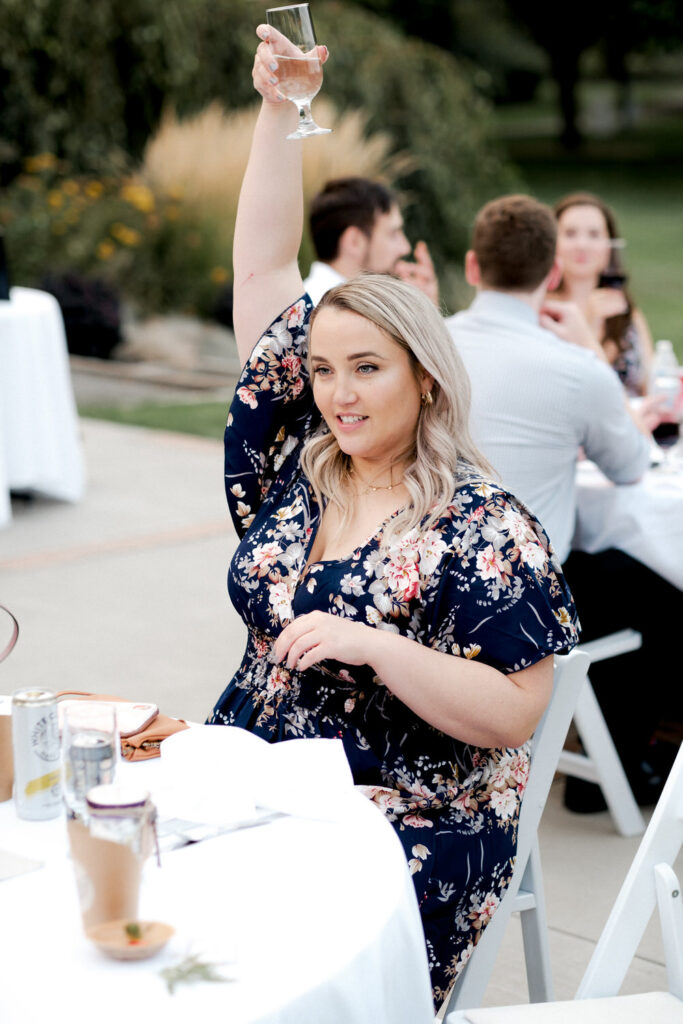 Wedding guest holds up her champagne glass
