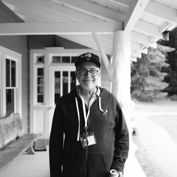 Olympic National Park Wedding | Sara and Robert's Summer Camp Wedding Weekend at NatureBridge 7 Portrait of guest standing on cabin porch at NatureBridge Olympic summer camp wedding in Olympic National Park