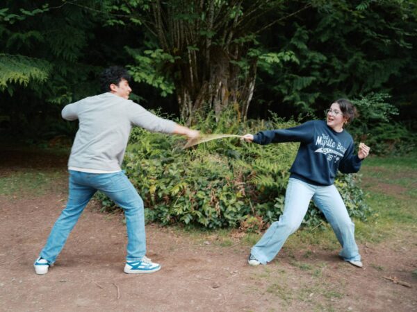 Olympic National Park Wedding | Sara and Robert's Summer Camp Wedding Weekend at NatureBridge 12 Couple playing in a forest clearing during welcome dinner at NatureBridge Olympic in Olympic National Park