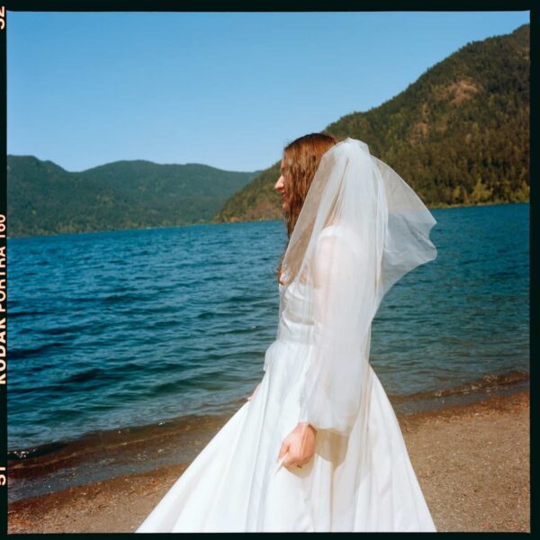 Olympic National Park Wedding | Sara and Robert's Summer Camp Wedding Weekend at NatureBridge 22 Bride standing in profile by lake in veil during outdoor summer camp wedding
