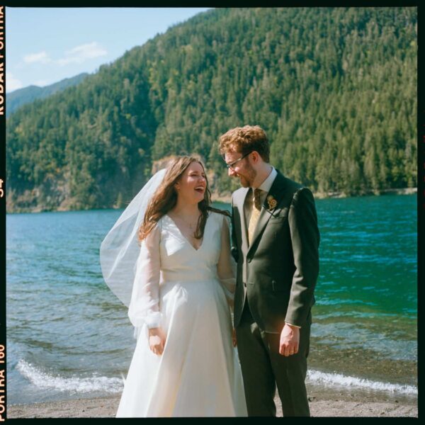 Olympic National Park Wedding | Sara and Robert's Summer Camp Wedding Weekend at NatureBridge 24 Bride and groom laughing together on lakeshore during intimate Olympic National Park wedding