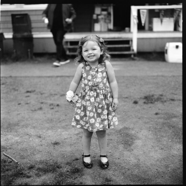 Olympic National Park Wedding | Sara and Robert's Summer Camp Wedding Weekend at NatureBridge 37 Black and white portrait of flower girl smiling during family-friendly wedding celebration