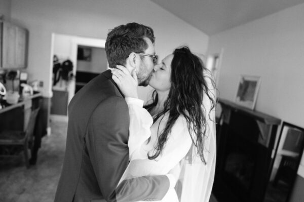 Olympic National Park Wedding | Sara and Robert's Summer Camp Wedding Weekend at NatureBridge 28 Bride and groom kissing during quiet moment before lakeside wedding ceremony
