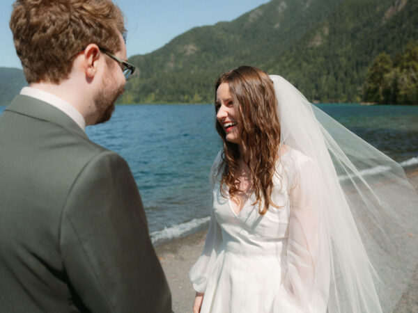 Olympic National Park Wedding | Sara and Robert's Summer Camp Wedding Weekend at NatureBridge 23 Bride laughing with groom on lakeshore during outdoor Olympic National Park wedding