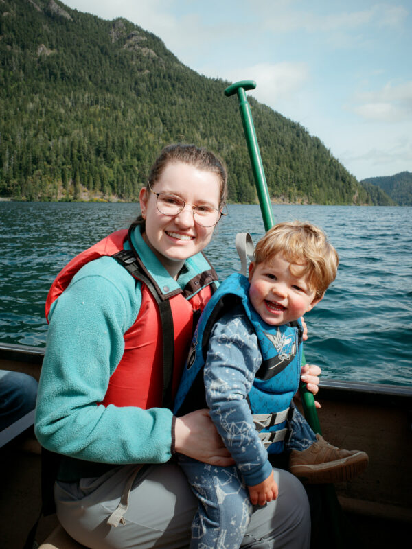 Olympic National Park Wedding | Sara and Robert's Summer Camp Wedding Weekend at NatureBridge 57 Bride and nephew smiling in canoe during family canoe trip on Lake Crescent