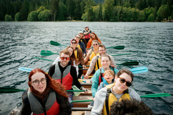 Olympic National Park Wedding | Sara and Robert's Summer Camp Wedding Weekend at NatureBridge 60 Guests paddling in rhythm during group canoe trip on Lake Crescent