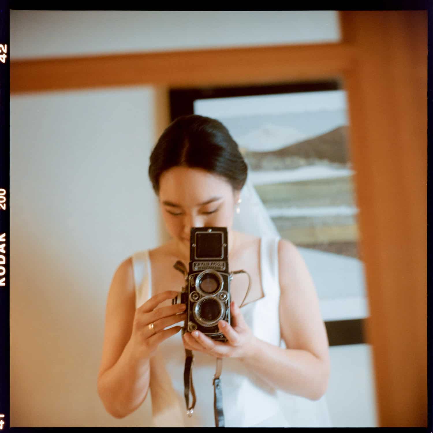 The Edgewater Hotel Wedding | Candid Seattle Wedding Photography for Amy & Mike 5 Amy holding a vintage film camera in her Edgewater Hotel suite before the wedding in Seattle, WA