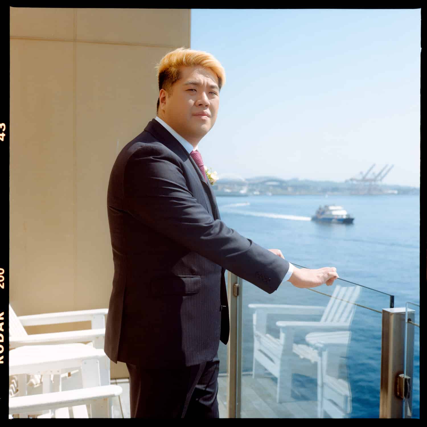 The Edgewater Hotel Wedding | Candid Seattle Wedding Photography for Amy & Mike 7 Mike standing on the Edgewater Hotel balcony overlooking Elliott Bay on the morning of the wedding