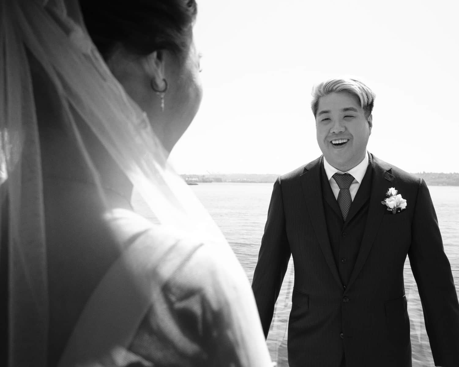 The Edgewater Hotel Wedding | Candid Seattle Wedding Photography for Amy & Mike 9 Mike smiling as he sees Amy for the first look by the waterfront at the Edgewater Hotel in Seattle