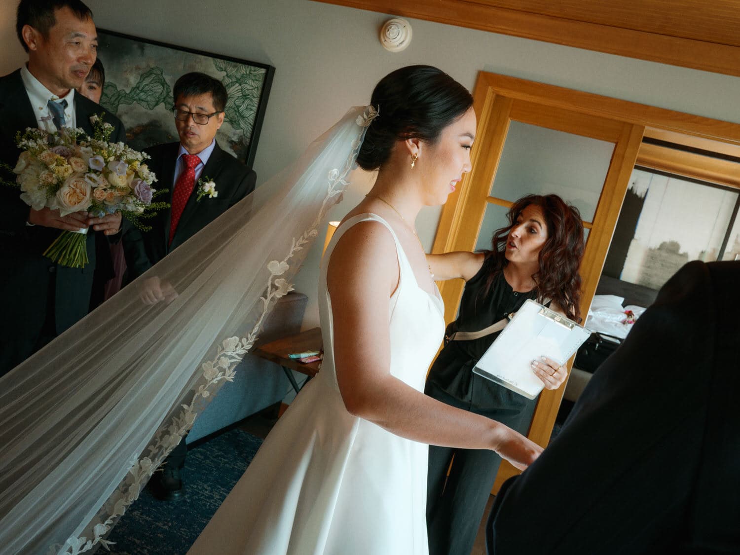 The Edgewater Hotel Wedding | Candid Seattle Wedding Photography for Amy & Mike 12 Bride getting final touches from her planner before walking out with her bouquet at the Edgewater Hotel wedding
